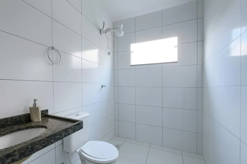 Banheiro da casa em Campo Alegre com bancada, lavatório, vaso sanitário, chuveiro e janela