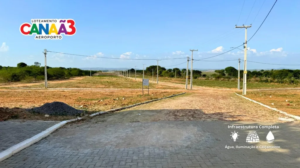 Acesso ao Canaã 3 com pavimentação, postes e terrenos; imagem registra as condições na data da fotografia