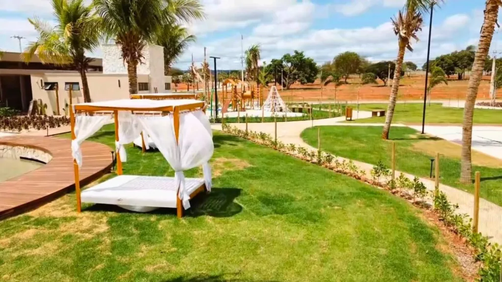 Bangalô junto à água, jardins e playground ao fundo no Conviver Riviera