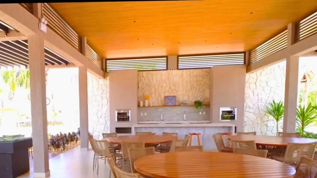 Espaço gourmet do Conviver Riviera com mesas, bancadas e churrasqueiras