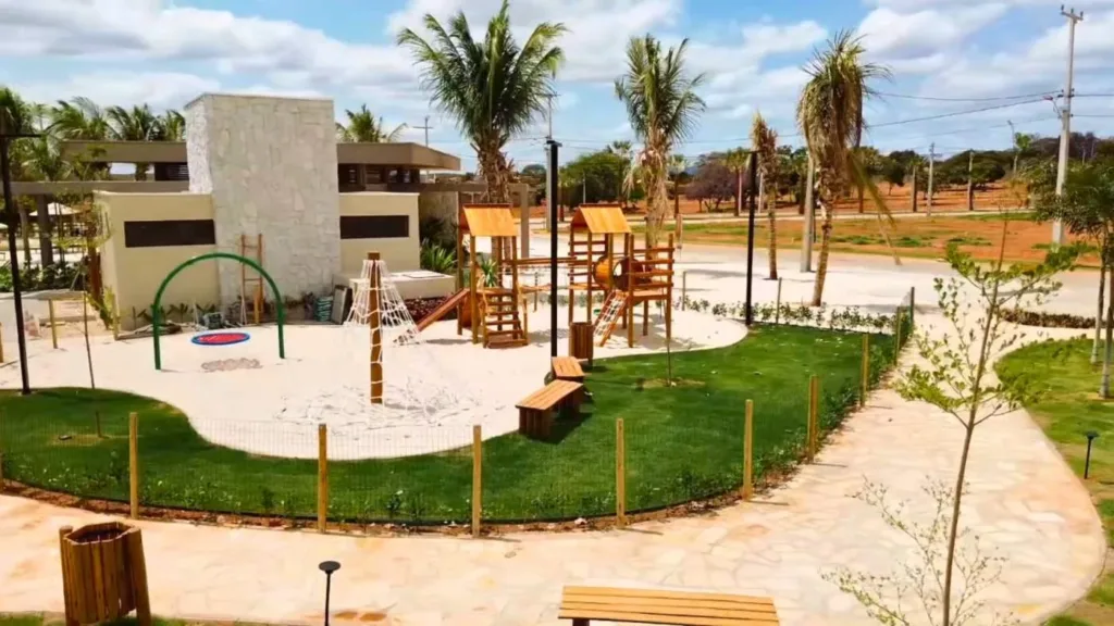 Playground com brinquedos de madeira e área ajardinada no Conviver Riviera