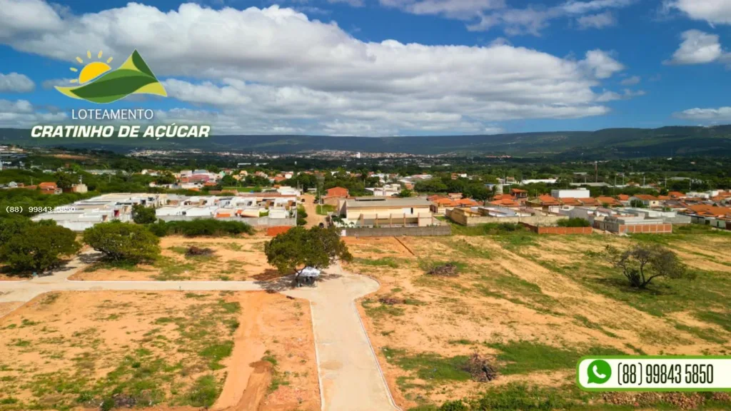 Via e terrenos do Cratinho de Açúcar com residências e serra ao fundo