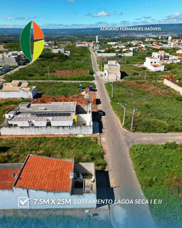 Rua asfaltada e terrenos do Lagoa Seca I e II, com a serra ao fundo