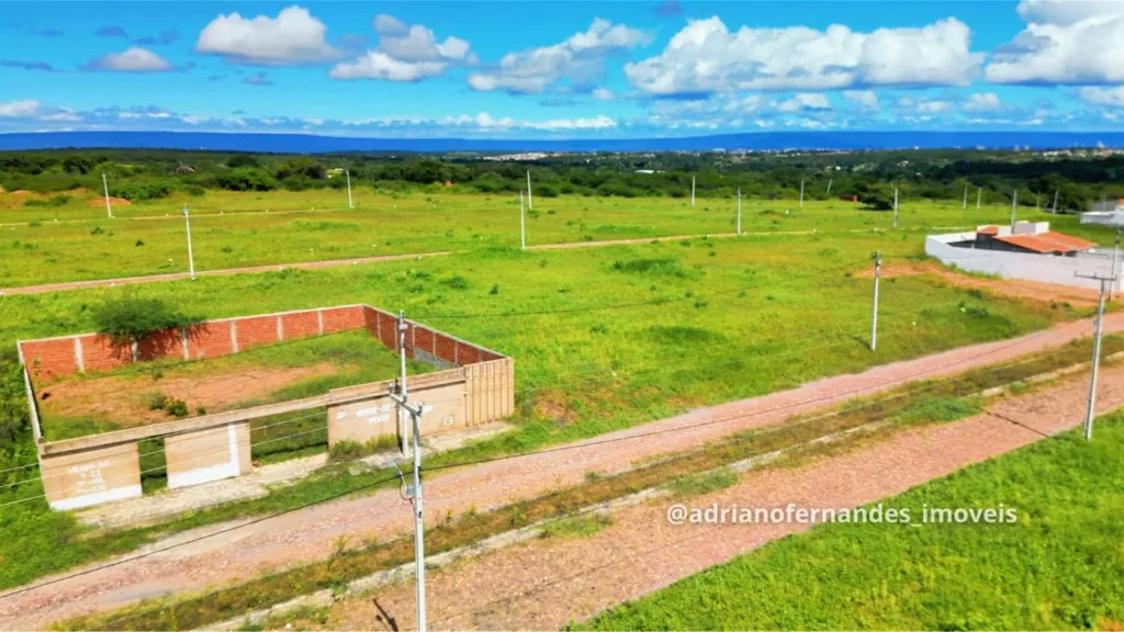 Terrenos, via e postes no Sombra do Juá, com imóvel murado no entorno