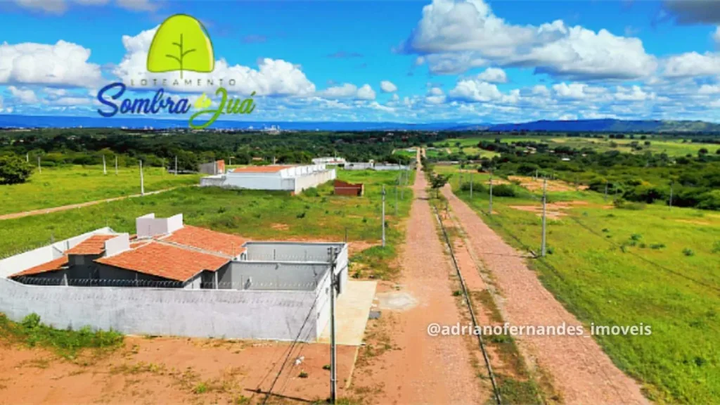 Via pavimentada, postes e residências no entorno dos lotes do Sombra do Juá