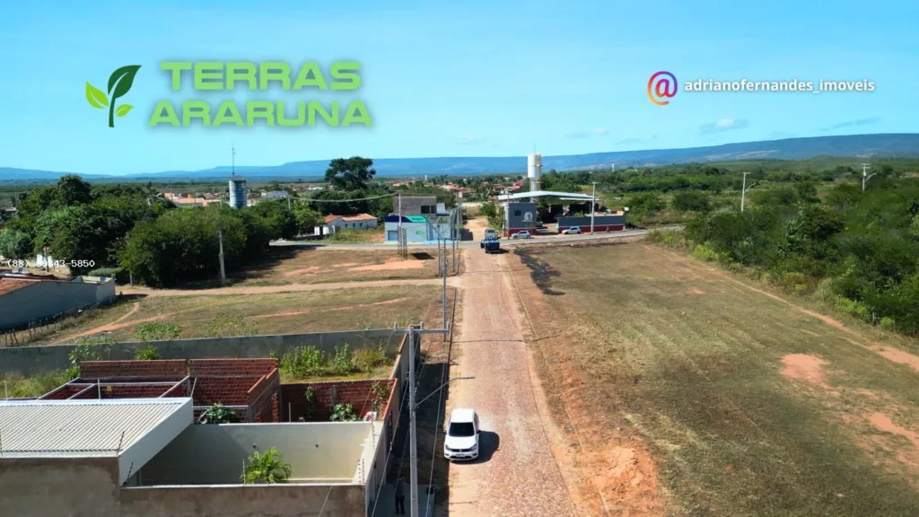 Via pavimentada do Terras Araruna em direção à rodovia, com construções no entorno